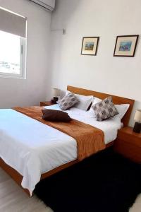 马普托Sweet Home的卧室配有一张带白色床单的大床和窗户。