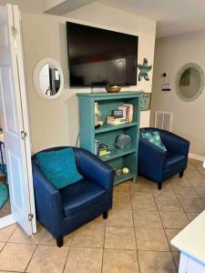 泰比岛Mini Pearl, Private 2 BR - 1 block to BEACH!的客厅配有2把蓝色椅子和电视