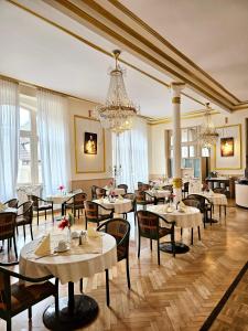 普福尔茨海姆格拉酒店的一间带桌椅和吊灯的餐厅