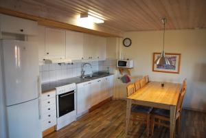 伊德菲尔Idre Fjäll, Söderbyn Ski in Ski out, 30 m till pisten的厨房配有木桌和白色冰箱。