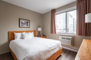 蒙特利尔罗贝瓦尔酒店的一间卧室设有一张大床和一个窗户。