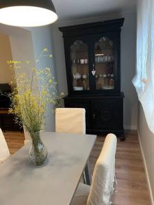 萨拉戈萨Precioso y céntrico apartamento的一间设有白色桌子和黑色橱柜的用餐室