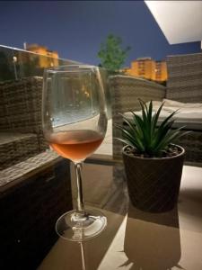 布拉索夫Plaza Residence的坐在桌子上,一边喝一杯葡萄酒,一边种上植物
