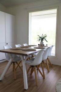 罗瓦涅米Big apartment, near Santaclaus Village的白色的用餐室配有桌椅