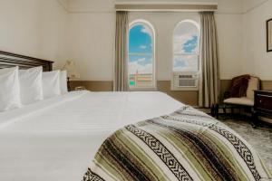 普雷斯科特圣米迦勒酒店的卧室配有一张白色大床和两个窗户