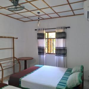 代尼耶耶Sinharaja Gingaga Homestay的一间卧室设有一张床和一个窗口