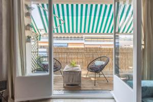 罗克布吕讷-卡普马丹Lovely Apartment near Monaco的通向带椅子和桌子的阳台的开放式门