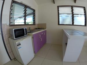 阿鲁坦加拉尼纽伊日落别墅的小厨房配有紫色橱柜和微波炉