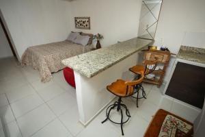圣特雷莎Loft c localizacao perfeita e WiFi-Santa Teresa ES的一间卧室配有一张床和一个带凳子的柜台