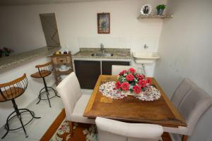 圣特雷莎Loft c localizacao perfeita e WiFi-Santa Teresa ES的厨房配有带鲜花的木桌