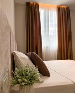 伏罗拉Solea Hotel的卧室配有带枕头的床铺和窗户。