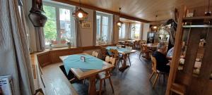 EschlikonHotel / Restaurant Post的一间设有桌子的餐厅,有人坐在餐厅里