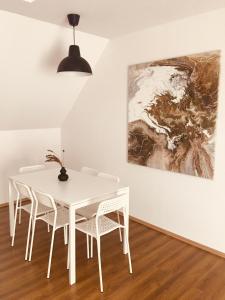 维斯普雷姆Pataky Apartmanok的白色的用餐室配有白色的桌椅