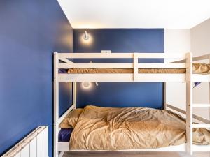 科克赛德Cottage B10的蓝色墙壁的客房内的双层床