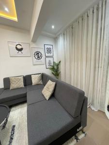 AshaimanModern Family House with 2 bedrooms + Free Parking的客厅在窗户前配有灰色沙发