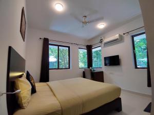 班加罗尔The Royal Living I Indiranagar的一间卧室设有一张床和两个窗户。