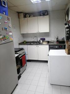 阿布扎比ETAS Residence的厨房配有白色橱柜和冰箱。