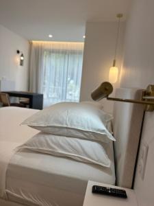 阿格德角Le cap dagde的一间卧室配有带白色床单和枕头的床。