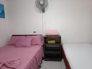 帕沃内斯Cabinas carol的一间带两张床和风扇的小卧室