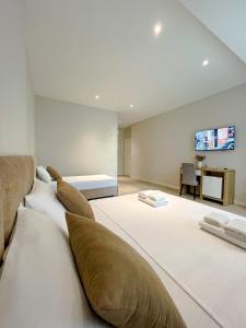 伏罗拉Solea Hotel的大房间设有两张床和一台墙上的电视