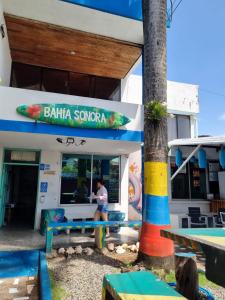 圣安德烈斯Posada Cultural Bahia Sonora的坐在冲浪店外长凳上的女人