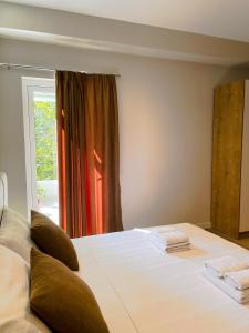 伏罗拉Solea Hotel的卧室配有一张大白色床和窗户