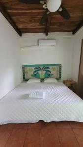 TamaniqueHotel Zelen的卧室配有白色的床和吊扇