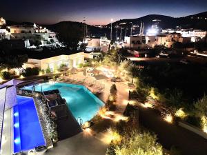 伊奥斯乔拉Relux Ios Hotel的享有游泳池的夜间景致