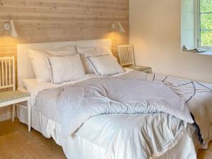 Skurup4 person holiday home in SKURUP的卧室配有一张带白色床单和枕头的大床。