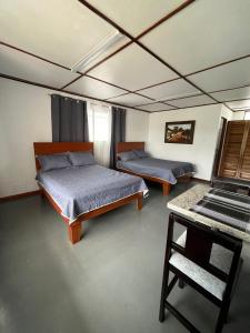 阿拉胡埃拉MARIO的一间设有两张床和一张桌子的房间