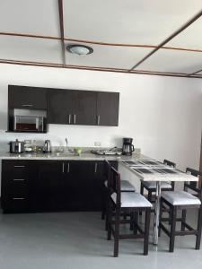 阿拉胡埃拉MARIO的厨房配有黑色橱柜和桌椅