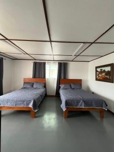 阿拉胡埃拉MARIO的一间卧室设有两张床和窗户。
