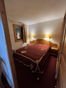 普拉涅村Plagne Villages, Charmante Résidence de Tourisme 4 Etoiles的一间小卧室,配有一张带红色毯子的床