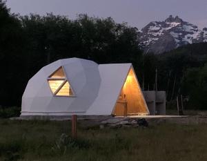 特来凡林Nomade Patagonia Glamping & Domos的田野上的小白色房子,有窗户