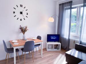 布吕尔NOVA Apartment- Phantasialand I Köln I Bonn的一间设有桌子和墙上时钟的餐厅