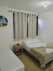 马塞约Pousada Águas Marinhas的一间卧室设有两张床和窗户。