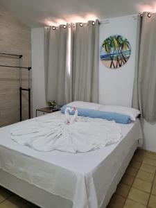 马塞约Pousada Águas Marinhas的卧室配有白色的床和天鹅
