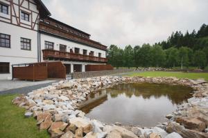 克维尔达Strunzova pila - wellness的一座建筑前池塘周围的石墙