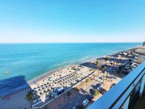 福恩吉罗拉Europa Beach House Vistas panorámicas al mar的享有海滩的空中景致,配有遮阳伞和海洋