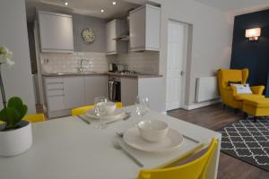 切斯特Charming 1 bed riverside apartment的厨房以及带白色桌子和黄色椅子的用餐室。
