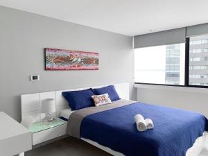 瓜亚基尔Penthouse de 2 habitaciones con vista al rio y parking的一间卧室设有蓝色的床和窗户。