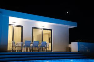 GalangádhosKyamon Estate Luxury Villa的一间配备有蓝色椅子和桌子的用餐室
