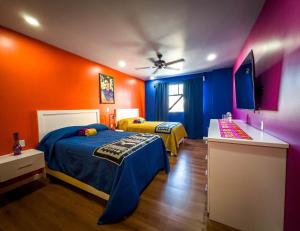 罗萨里托Hotel Cantaritos的橙色和蓝色的客房内的两张床