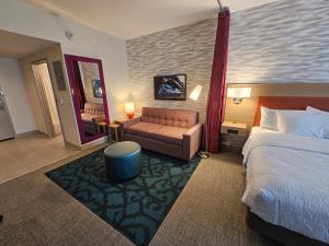 伯利恒Home2 Suites By Hilton Allentown Bethlehem Airport的酒店客房配有床、沙发和镜子