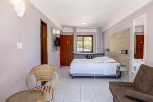 弗洛里亚诺波利斯Saint Germain - Lagoa da Conceição的一间卧室配有一张床、一把椅子和一张沙发