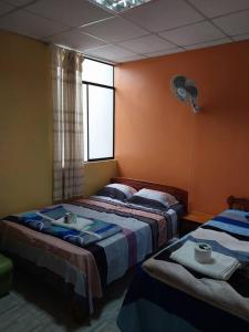 莫约班巴D-302的一间卧室设有两张床、一个窗口和风扇