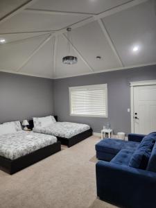 萨里Harmony Hospitality "Walking Distance to Surrey Central"的一间卧室配有两张床和蓝色的沙发