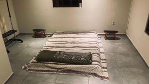 弗洛里亚诺波利斯Vila Verde casa com ar condicionado e vista da lagoa的一张床上床,床上有毯子,铺在地板上