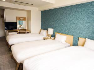 神户神户港湾塔酒店的酒店客房设有三张床和电视。