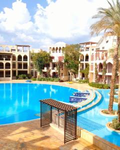 亚喀巴Flat Luxury 2 bed rooms apartment talabay aqaba的棕榈树和建筑度假村内的游泳池
